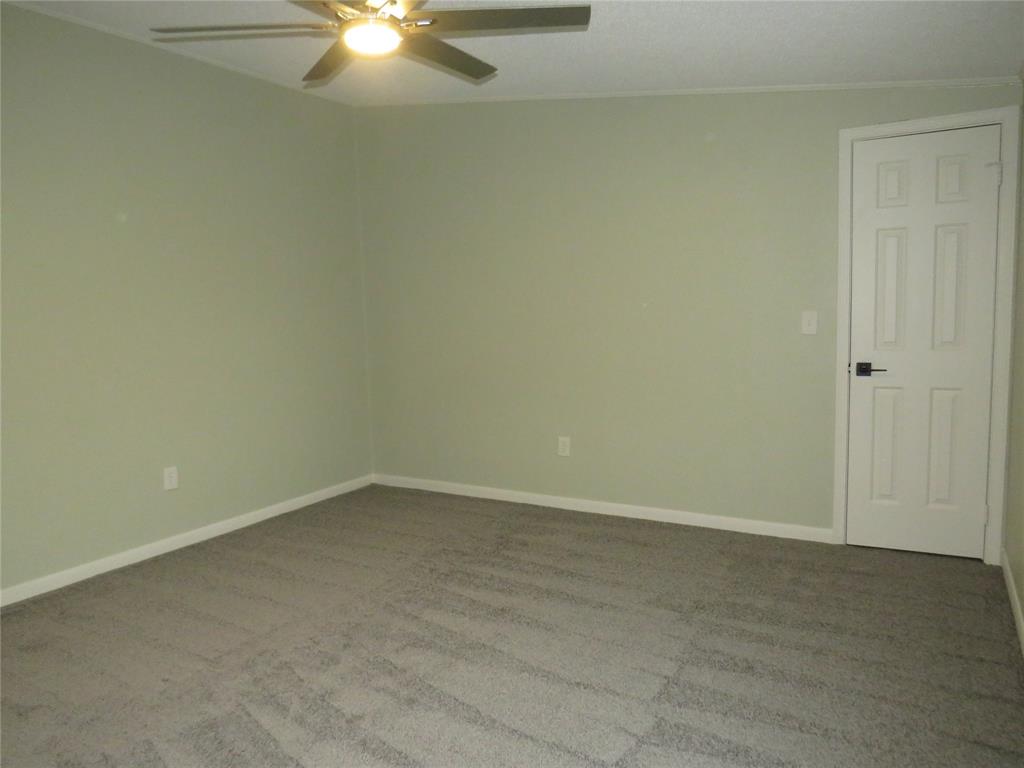 2151 Crockett Road Sanger, TX 76266 - Photo 10 of 30 an empty room with a ceiling fan and a window