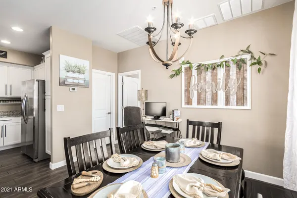 a dining room with furniture a chandelier and wooden floor