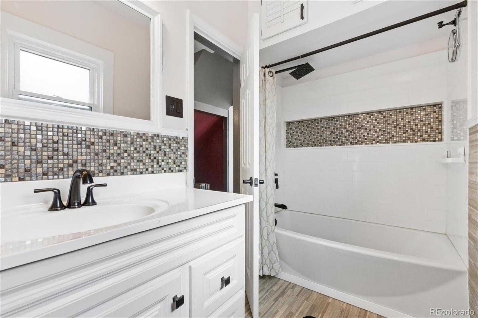 1275 Clinton Street Aurora, CO 80010 - Photo 14 of 33 a bathroom with a sink and a bathtub