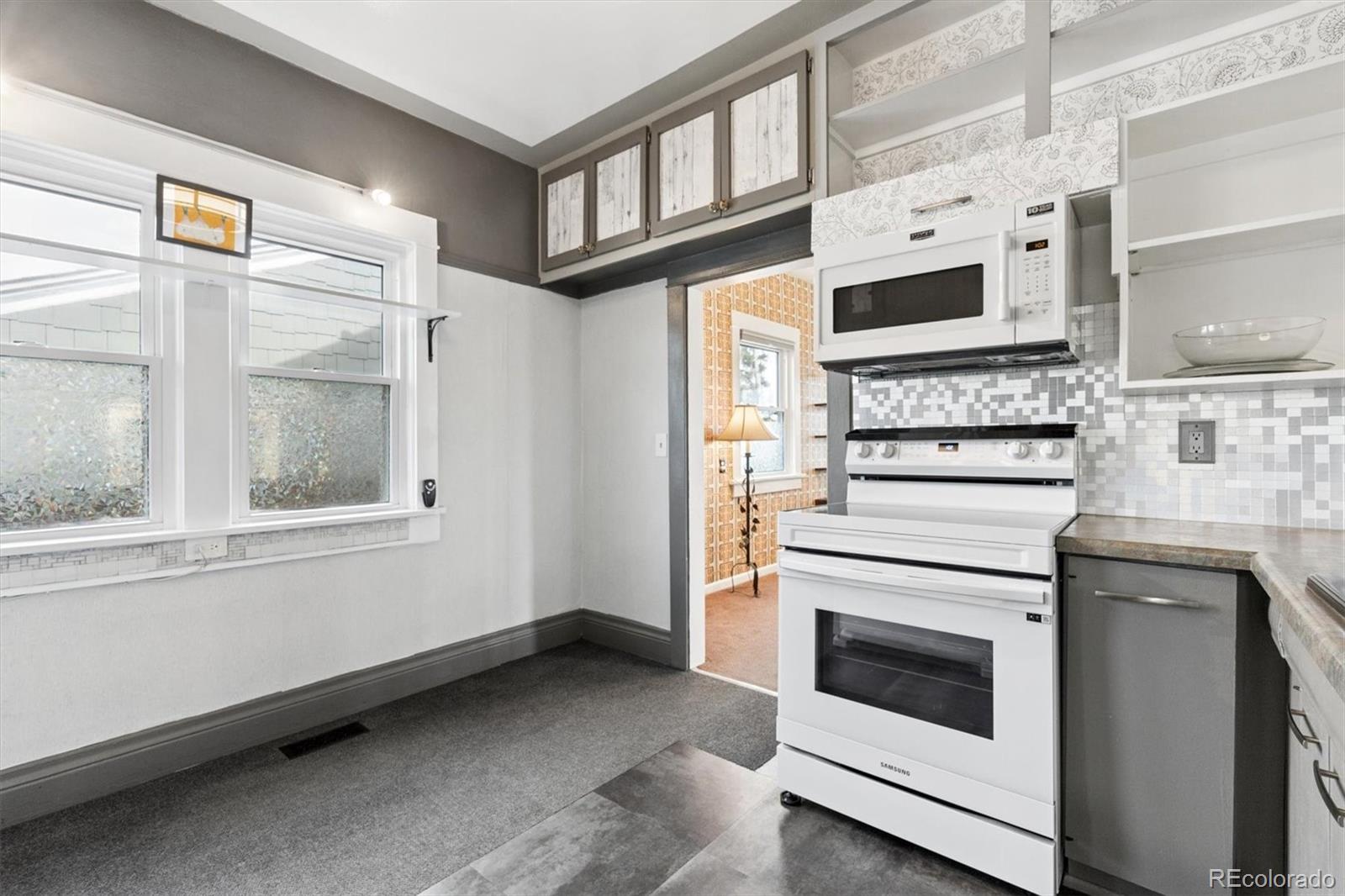 1275 Clinton Street Aurora, CO 80010 - Photo 15 of 33 a kitchen with stainless steel appliances white cabinets and a window