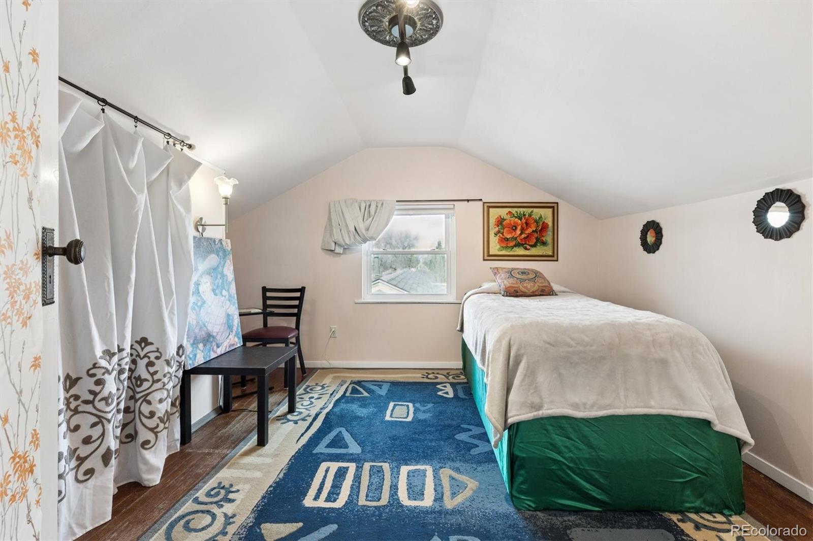 1275 Clinton Street Aurora, CO 80010 - Photo 23 of 33 a bedroom with a bed and a chandelier
