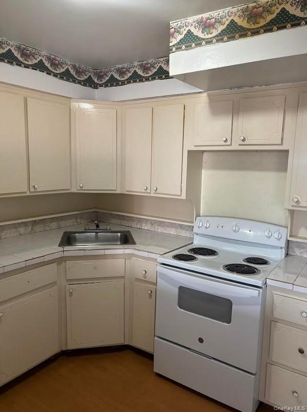 91-04 75th Street, Unit 2 Queens, NY 11421 - Photo 2 of 7 a kitchen with cabinets appliances a sink and a stove