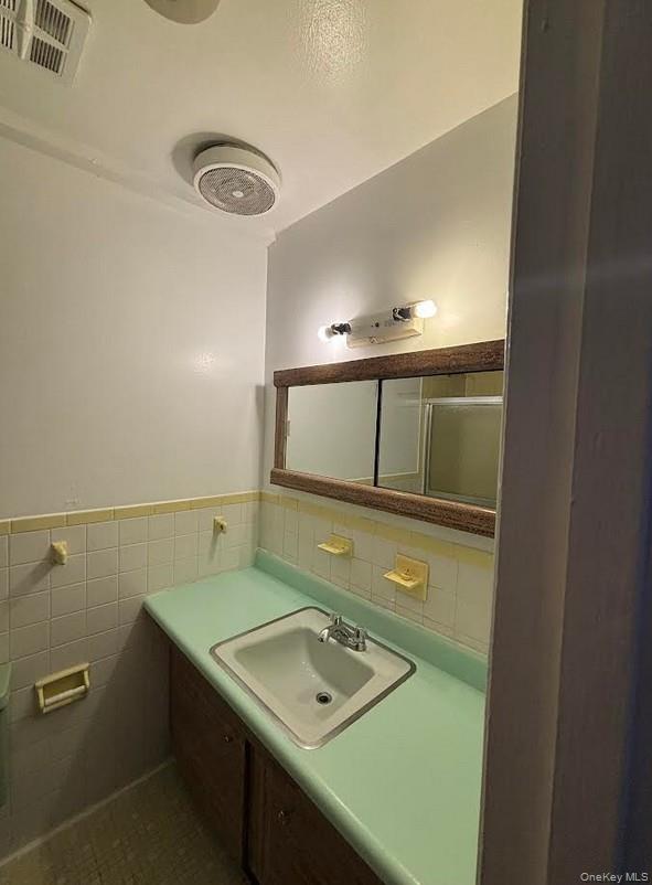 91-04 75th Street, Unit 2 Queens, NY 11421 - Photo 7 of 7 a bathroom with a sink and a mirror