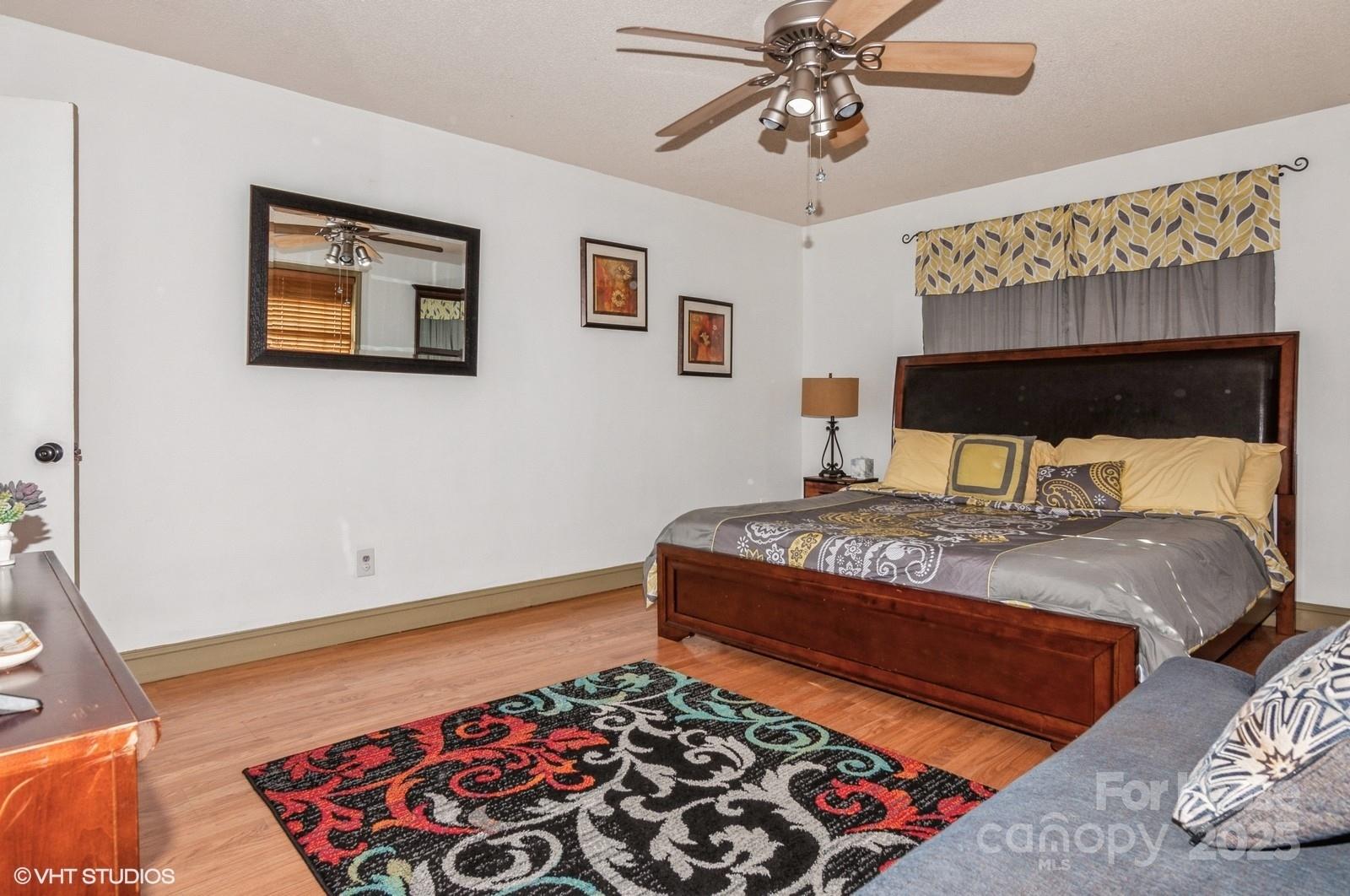 9938 Sandra Lane Fort Mill, SC 29707 - Photo 17 of 36 a bedroom with a bed and a chandelier