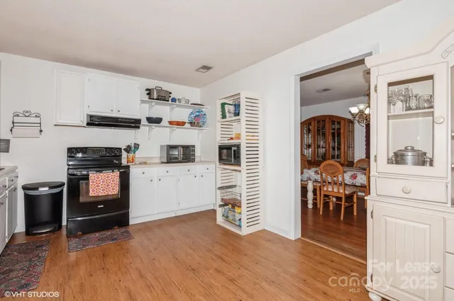 a kitchen with a refrigerator and a stove top oven