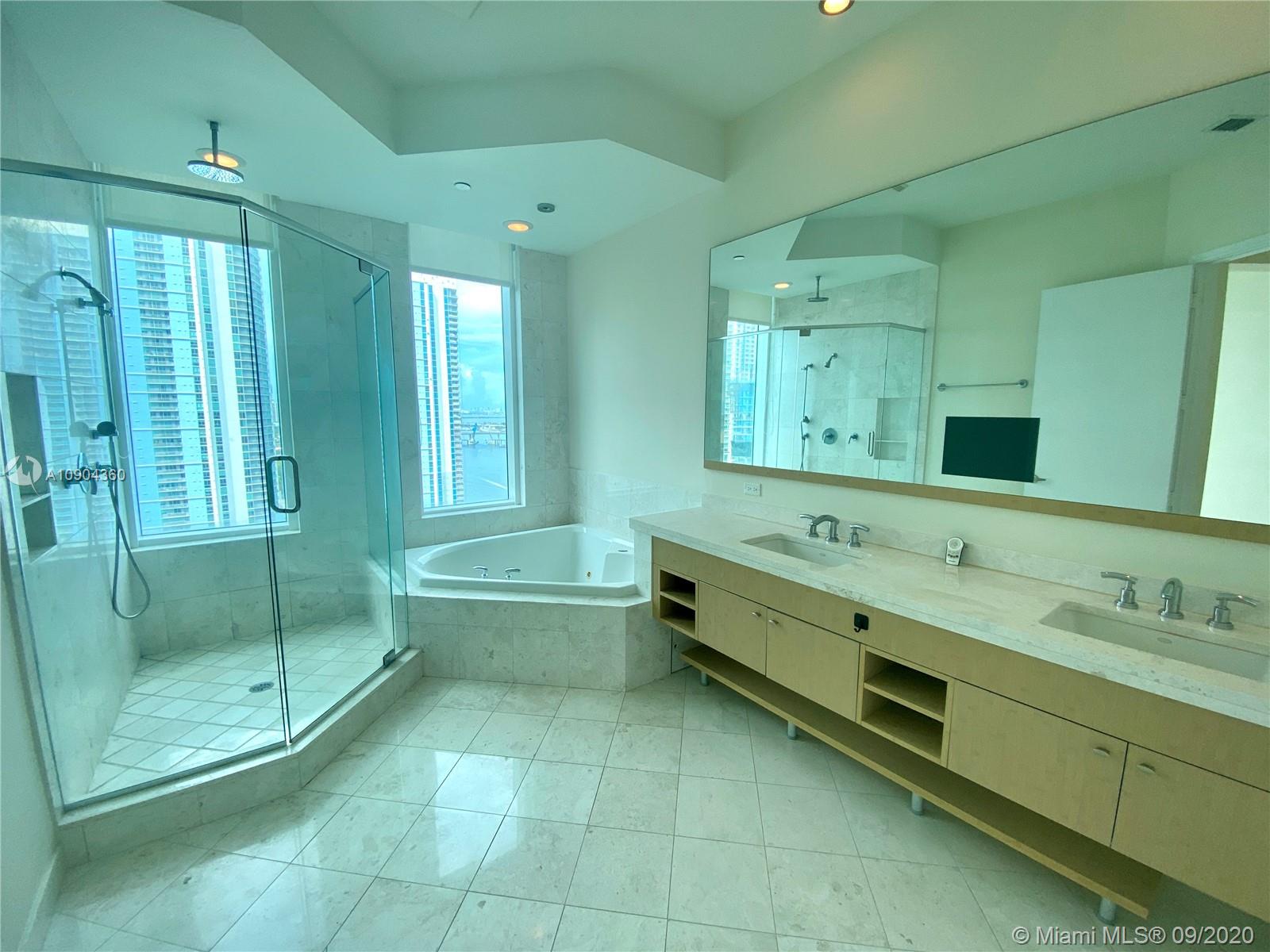 900 Brickell Key Boulevard, Unit 2001 Miami, FL 33131 - Photo 9 of 22 a bathroom with a double vanity sink mirror and shower