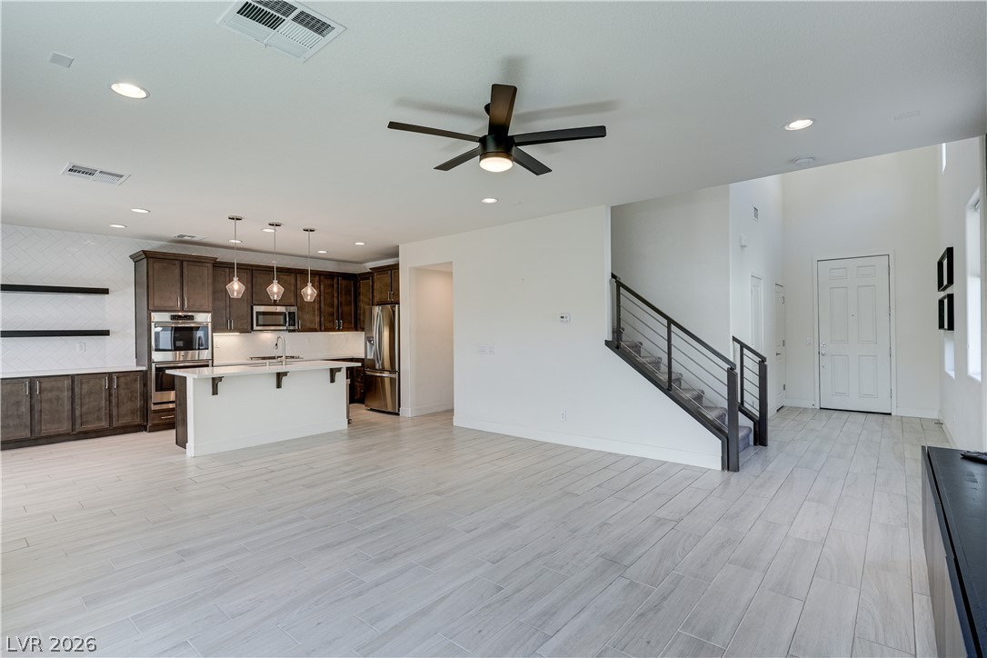 5954 Smith Valley Road Las Vegas, NV 89148 - Photo 11 of 23 An open-concept living space integrates a well-appointed kitchen with a welcoming entry and staircase.