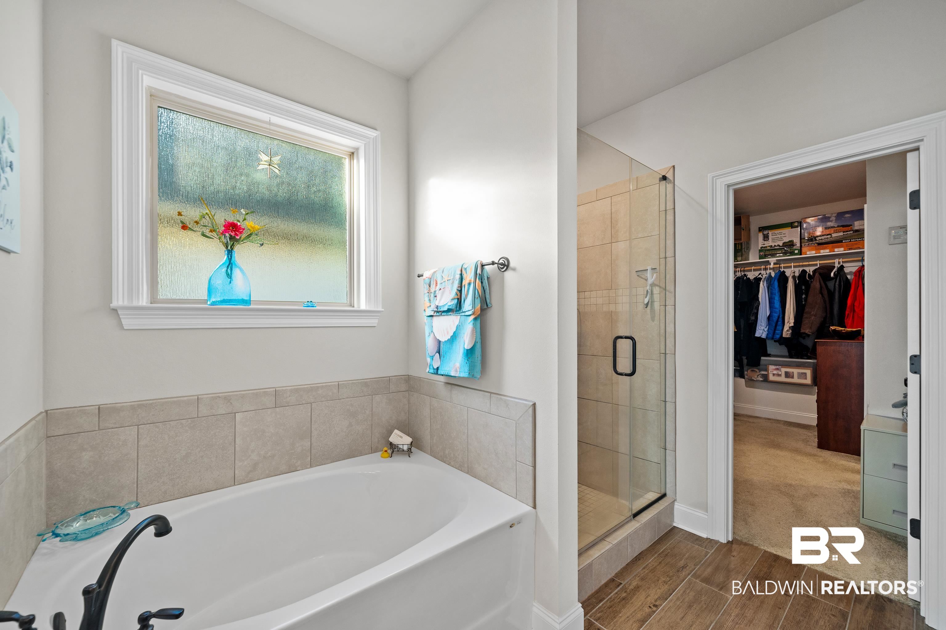 1390 Aldon Street Foley, AL 36535 - Photo 16 of 31 Full bathroom featuring a walk in closet, a bath, a shower stall, and wood tiled floors