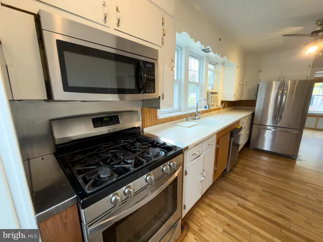 a kitchen with stainless steel appliances granite countertop a stove microwave and refrigerator
