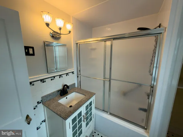 a bathroom with a shower sink and mirror