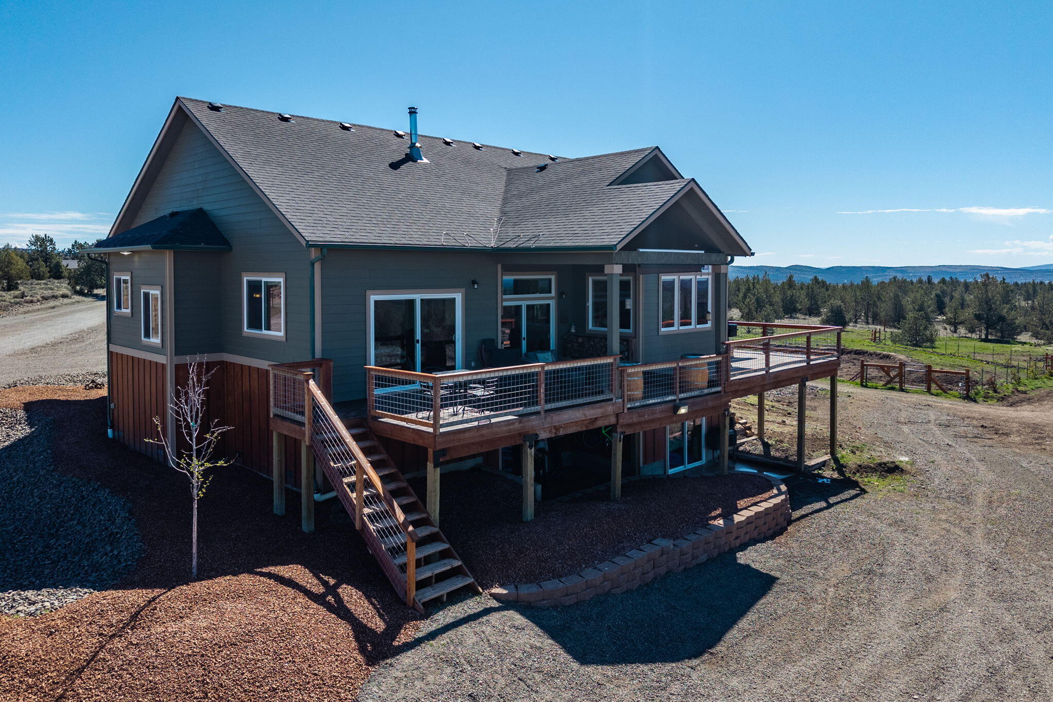 6040 Gravett Road Prineville, OR 97754 - Photo 49 of 77 a view of a house with backyard porch and wooden deck