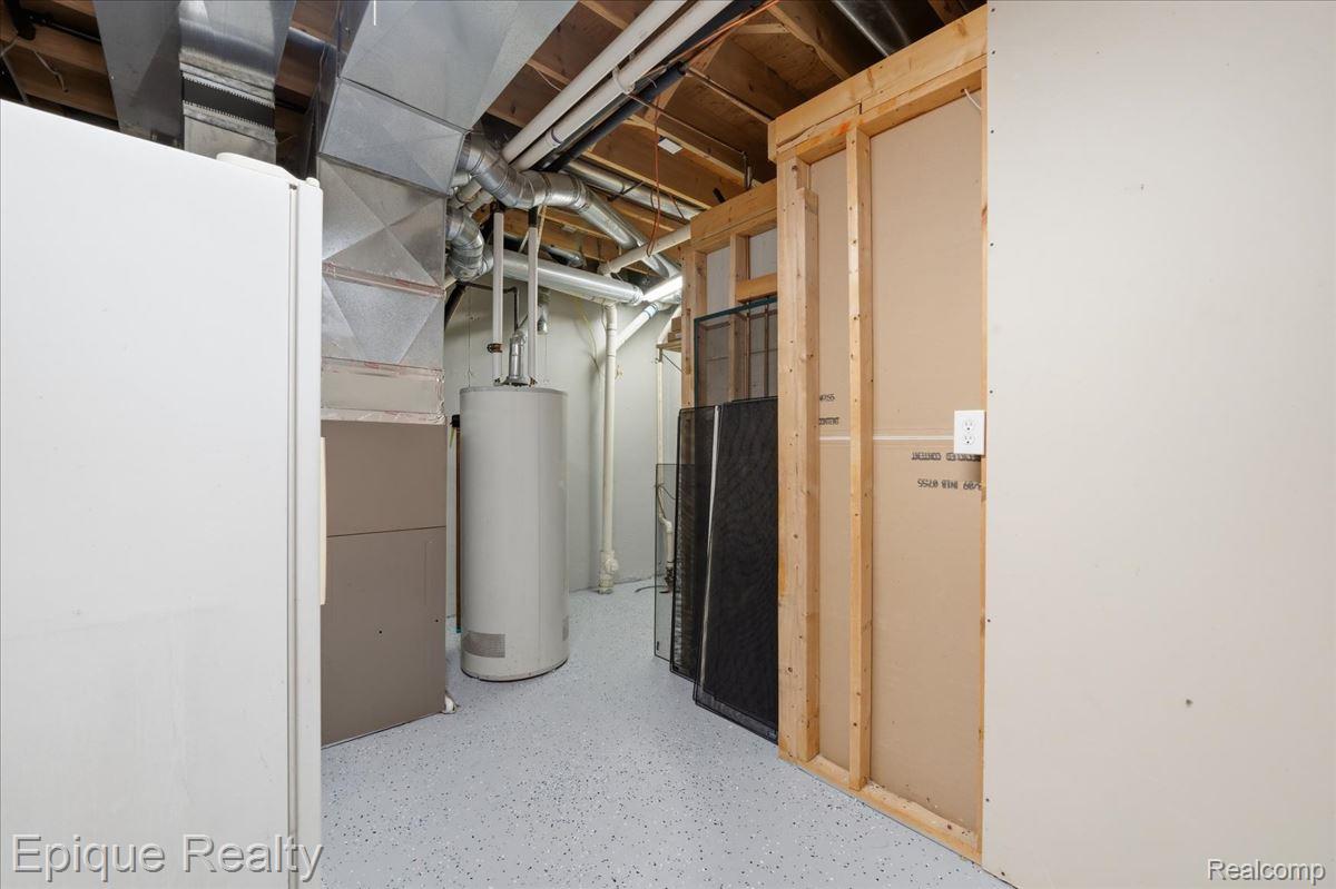 1221 Rhodes Road Lake Orion, MI 48360 - Photo 49 of 72 Utility room featuring exposed ductwork, a water heater, and a furnace, all situated on a light-toned, speckled epoxy floor