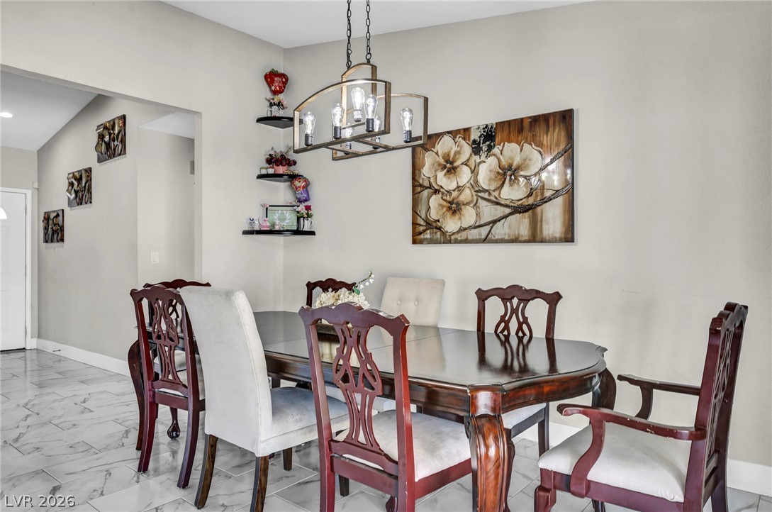5882 Rio Tinto Way Las Vegas, NV 89110 - Photo 40 of 56 An inviting dining area offers a linear chandelier and elegant tiled flooring.