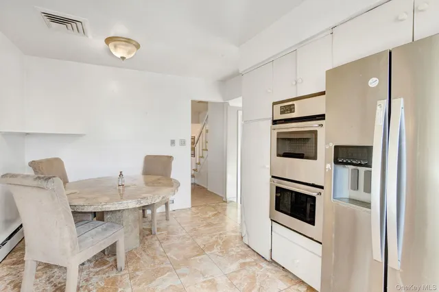 a kitchen with stainless steel appliances kitchen island granite countertop a table and chairs in it