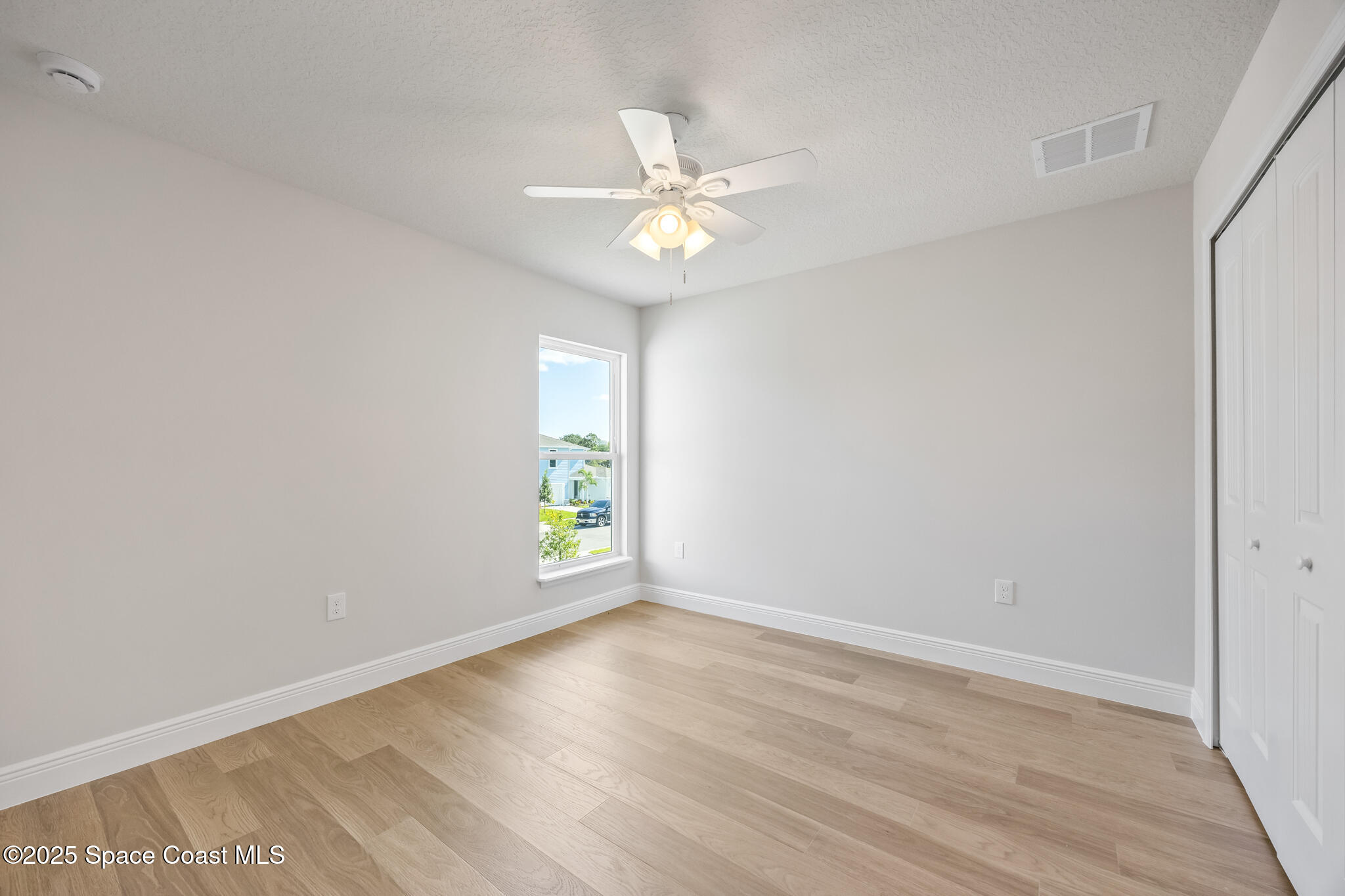 207 Hidden Woods Place Melbourne, FL 32901 - Photo 31 of 33 an empty room with window and a ceiling fan