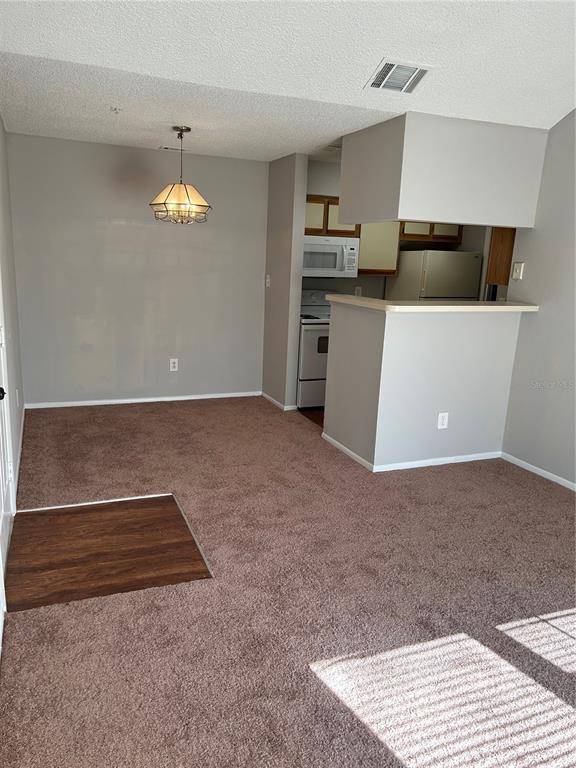 241 Afton Square, Unit 304 Altamonte Springs, FL 32714 - Photo 4 of 17 an empty room with kitchen and windows