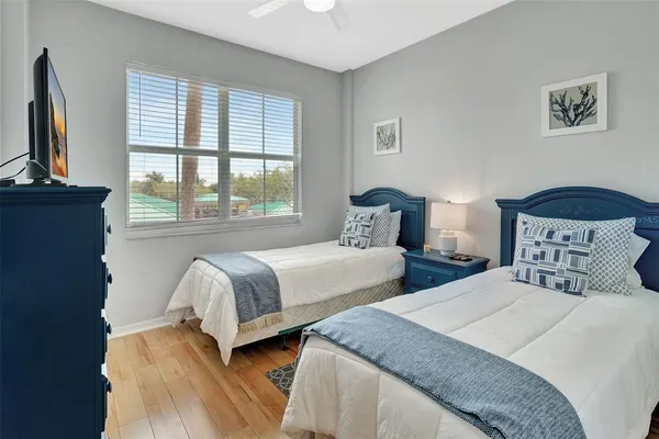 a bedroom with two beds and a large window