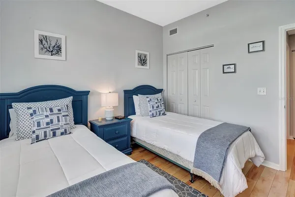 a bedroom with two beds and painting on the wall