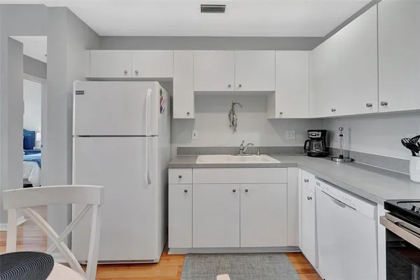 a kitchen with white cabinets and white appliances