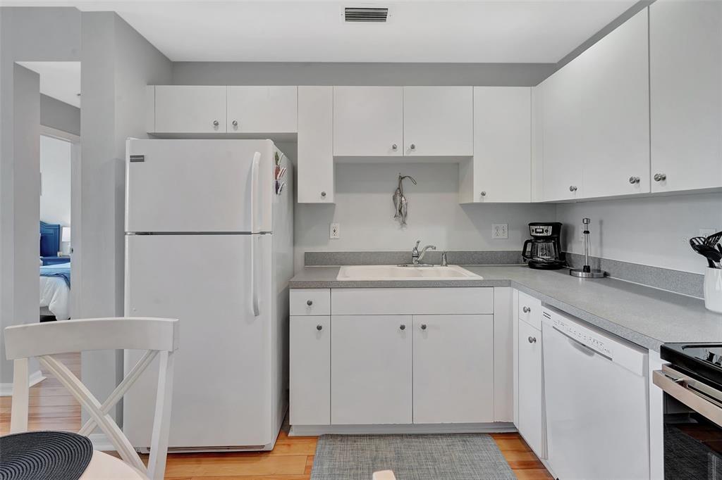 2090 Matecumbe Key Road, Unit 1207 Punta Gorda, FL 33955 - Photo 6 of 23 a kitchen with white cabinets and white appliances