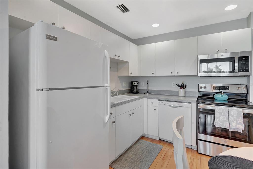 2090 Matecumbe Key Road, Unit 1207 Punta Gorda, FL 33955 - Photo 7 of 23 a kitchen with stainless steel appliances granite countertop a refrigerator a stove a sink and white cabinets