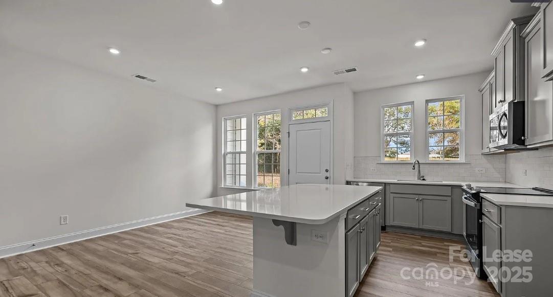 2035 Near Pt Road Charlotte, NC 28208 - Photo 5 of 13 a large kitchen with stainless steel appliances a sink and dishwasher with wooden floor
