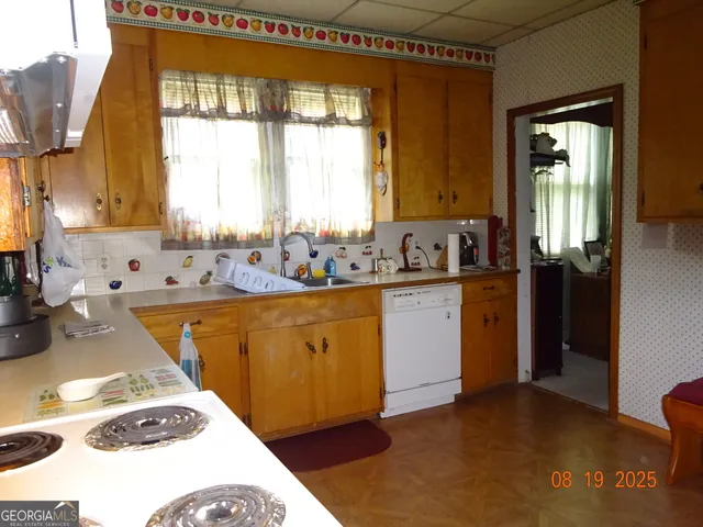 a kitchen with sink a window and cabinets