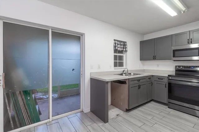 a kitchen with stainless steel appliances granite countertop a stove a sink and a refrigerator