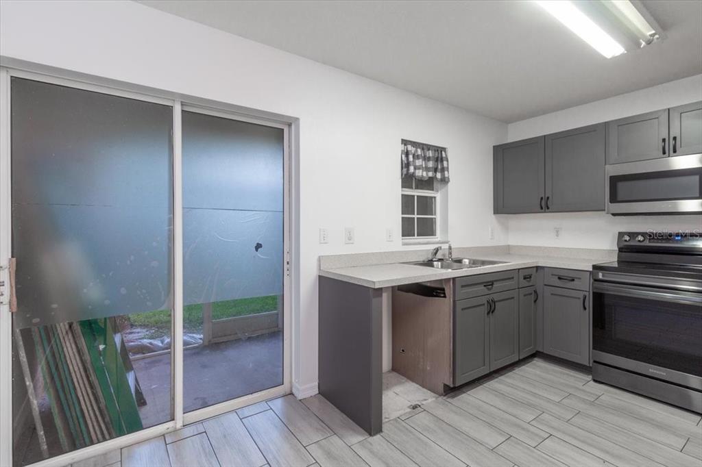 12946 Trade Port Place Riverview, FL 33579 - Photo 12 of 26 a kitchen with stainless steel appliances granite countertop a stove a sink and a refrigerator