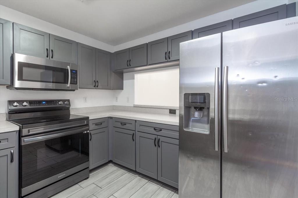 12946 Trade Port Place Riverview, FL 33579 - Photo 14 of 26 a kitchen with a refrigerator stove and microwave