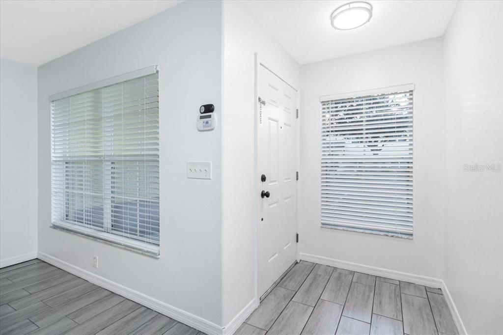 12946 Trade Port Place Riverview, FL 33579 - Photo 7 of 26 a view of an empty room with wooden floor and a window