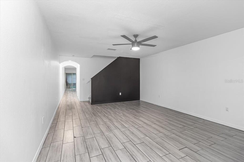 12946 Trade Port Place Riverview, FL 33579 - Photo 8 of 26 an empty room with wooden floor and ceiling fan