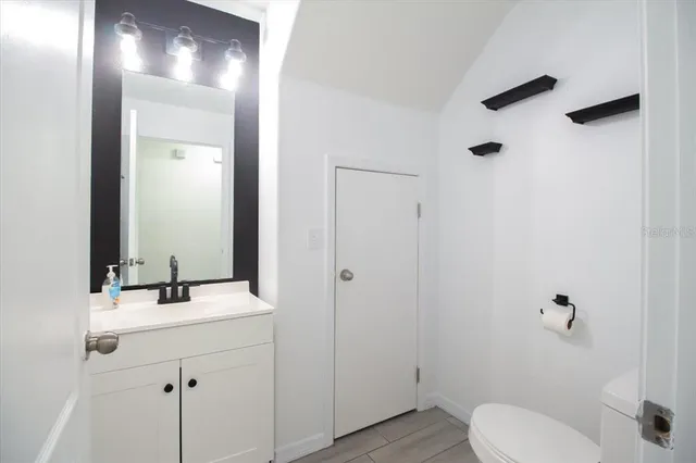 a bathroom with a toilet a sink and mirror