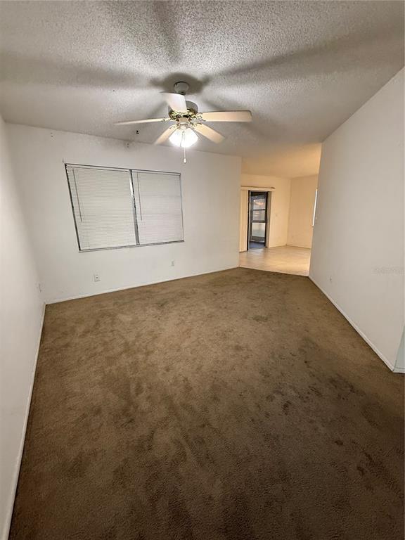 9007 Spring Hill Drive Spring Hill, FL 34608 - Photo 6 of 12 an empty room with windows and fan