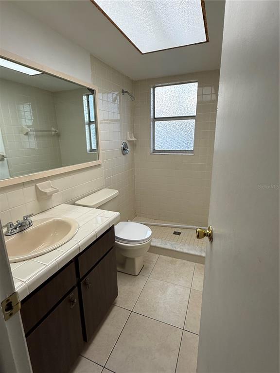 9007 Spring Hill Drive Spring Hill, FL 34608 - Photo 9 of 12 a bathroom with a granite countertop sink a toilet and a mirror
