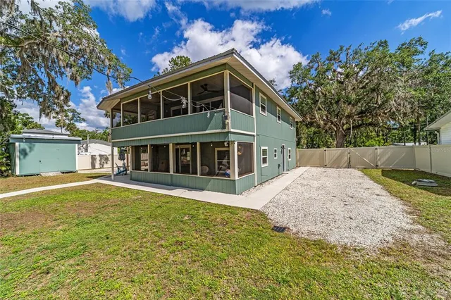 a view of a house with a large window and wooden fence