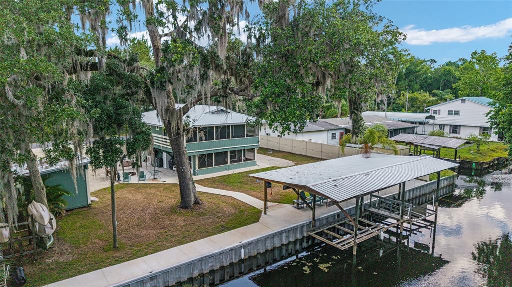 24628 Fox Road Astor, FL 32102 - Photo 17 of 96 a roof deck with table and chairs a barbeque with potted plants and large trees