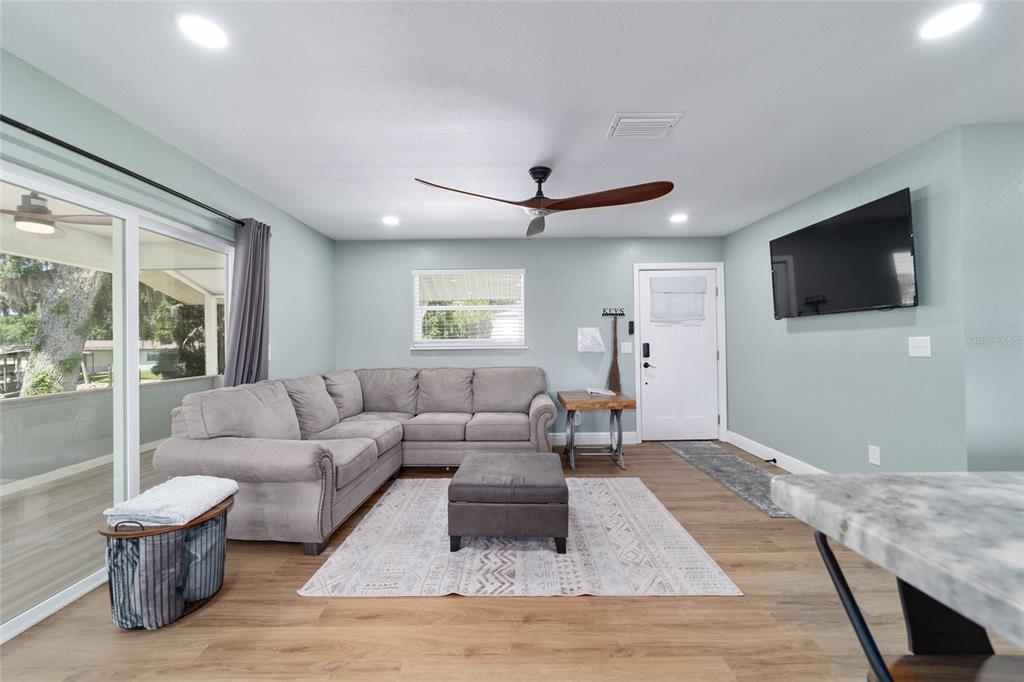 24628 Fox Road Astor, FL 32102 - Photo 78 of 96 a living room with furniture a flat screen tv and a large window