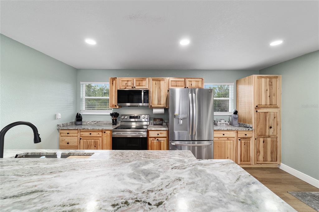 24628 Fox Road Astor, FL 32102 - Photo 87 of 96 a large kitchen with stainless steel appliances granite countertop a refrigerator stove microwave and sink