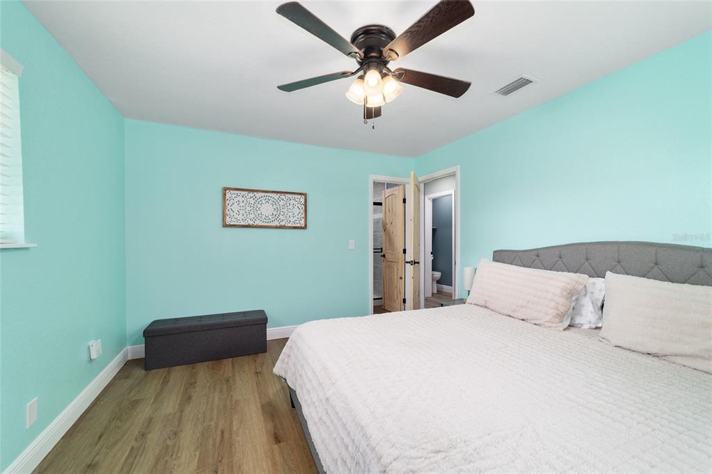 24628 Fox Road Astor, FL 32102 - Photo 96 of 96 a bedroom with a bed and a chandelier