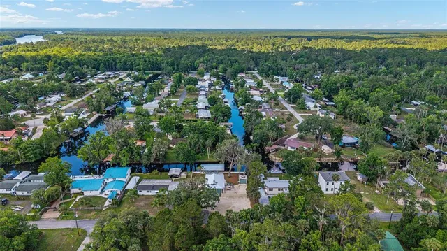 an aerial view of a house with a yard swimming pool and outdoor seating