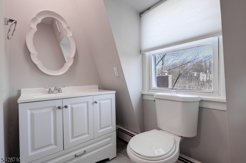 47 Ridgedale Avenue Morristown, NJ 07960 - Photo 10 of 14 a bathroom with a toilet a sink a mirror and a window