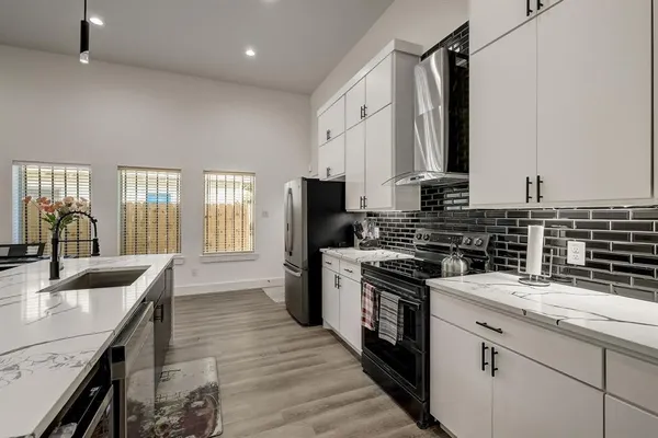 a kitchen with a sink stove top oven and refrigerator