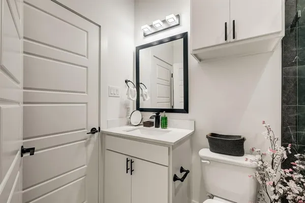 a bathroom with a toilet sink and mirror