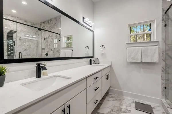 a bathroom with double vanity sink and a mirror
