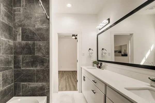 a bathroom with a double vanity sink a mirror and a shower