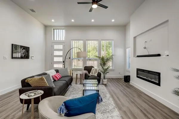 a living room with furniture fireplace and a large window