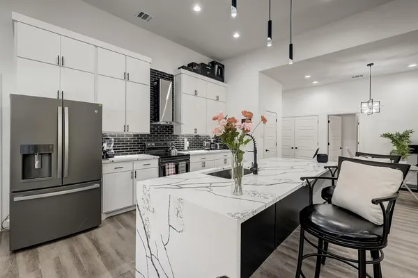 a kitchen with refrigerator and chairs