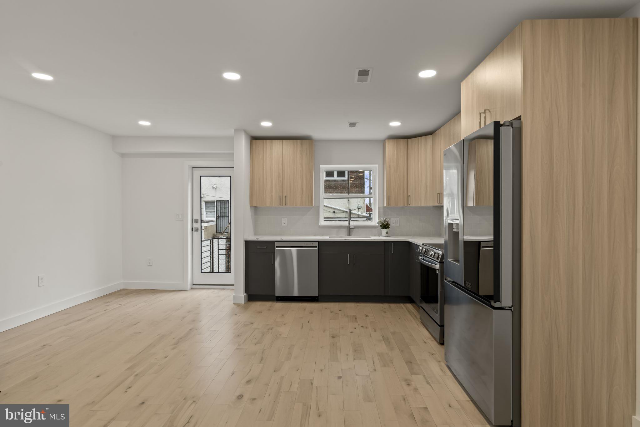2747 South Beulah Street Philadelphia, PA 19148 - Photo 7 of 37 a large kitchen with a refrigerator and a stove top oven