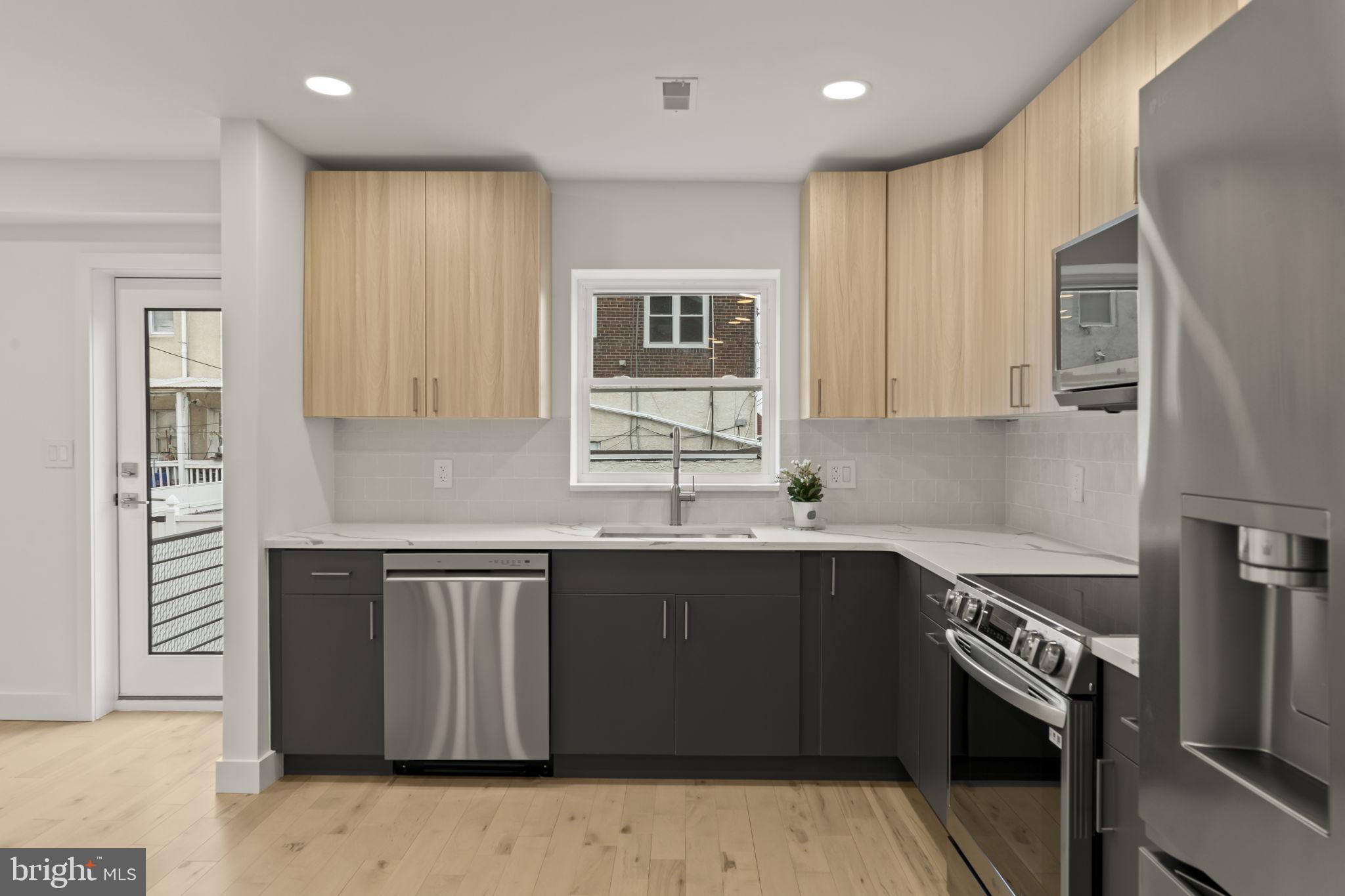 2747 South Beulah Street Philadelphia, PA 19148 - Photo 10 of 37 a kitchen with a sink stove and cabinets